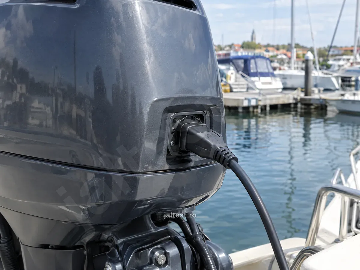 Cablul de diagnoză conectat la un motor outboard, la ponton, într-un port de ambarcațiuni.